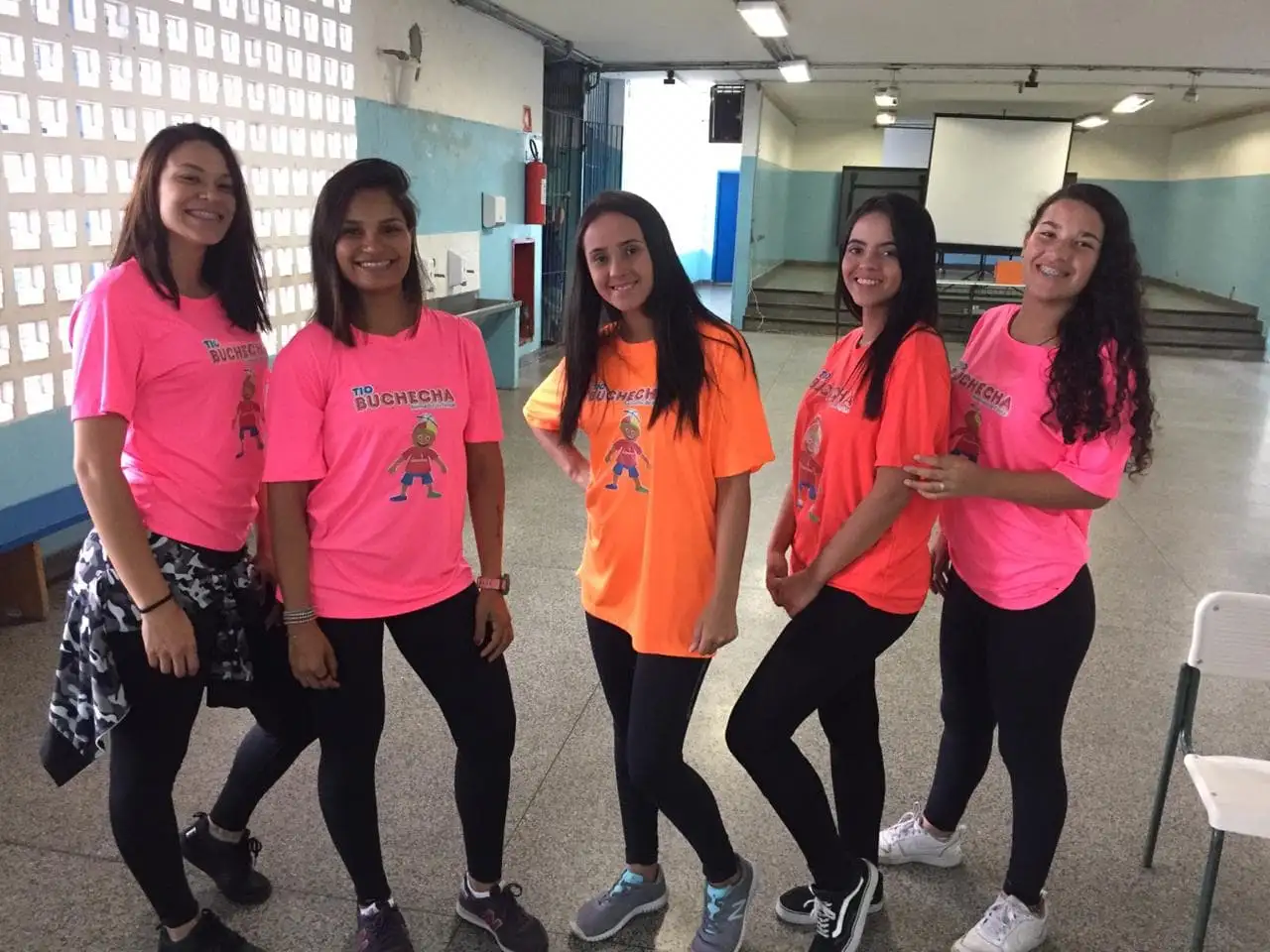 Cinco recreadoras da equipe Tio Buchecha posam com as camisetas da marca
